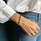Woman wearing Sienna garnet bracelet with jeans and a white shirt