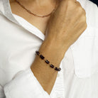 Woman wearing Sienna garnet bracelet with jeans and a white shirt