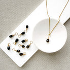 Smokey Quartz charm on a gold chain in a white dish