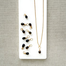 Smokey Quartz charm on a gold chain in a white dish
