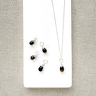 Smokey Quartz charm on a silver chain in a white dish