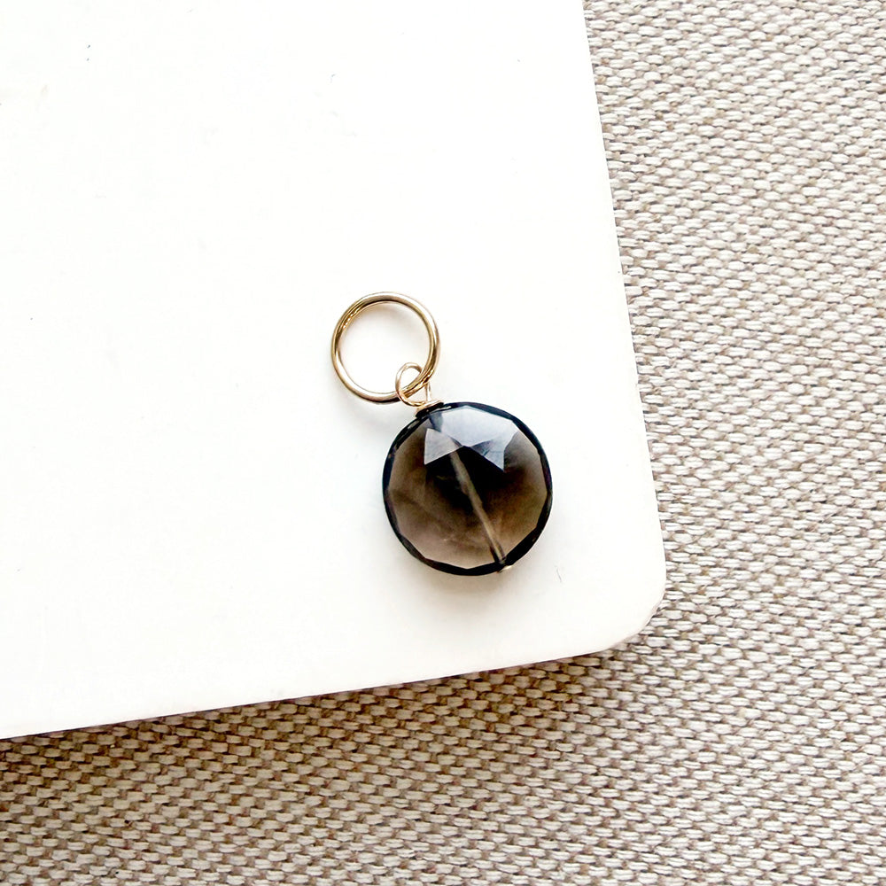 Smoky quartz charm on a white background