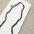 Clasp detail of smoky brown quartz knotted necklace with blue chalcedony carved pendant