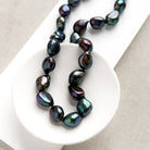 Peacock pearl statement necklace in a white dish