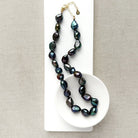 Peacock pearl statement necklace in a white dish