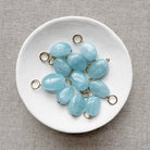 White dish filled with smooth oval aquamarine charms