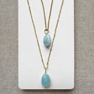 Two gold chains with smooth oval aquamarine charms