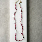 Gemstone necklace in shades of red on a white surface