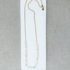 Stick pearl and gold chain necklace on a white background