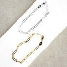 Two gold and silver chain bracelets on a white surface