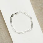 Silver paperclip chain bracelet on a light background