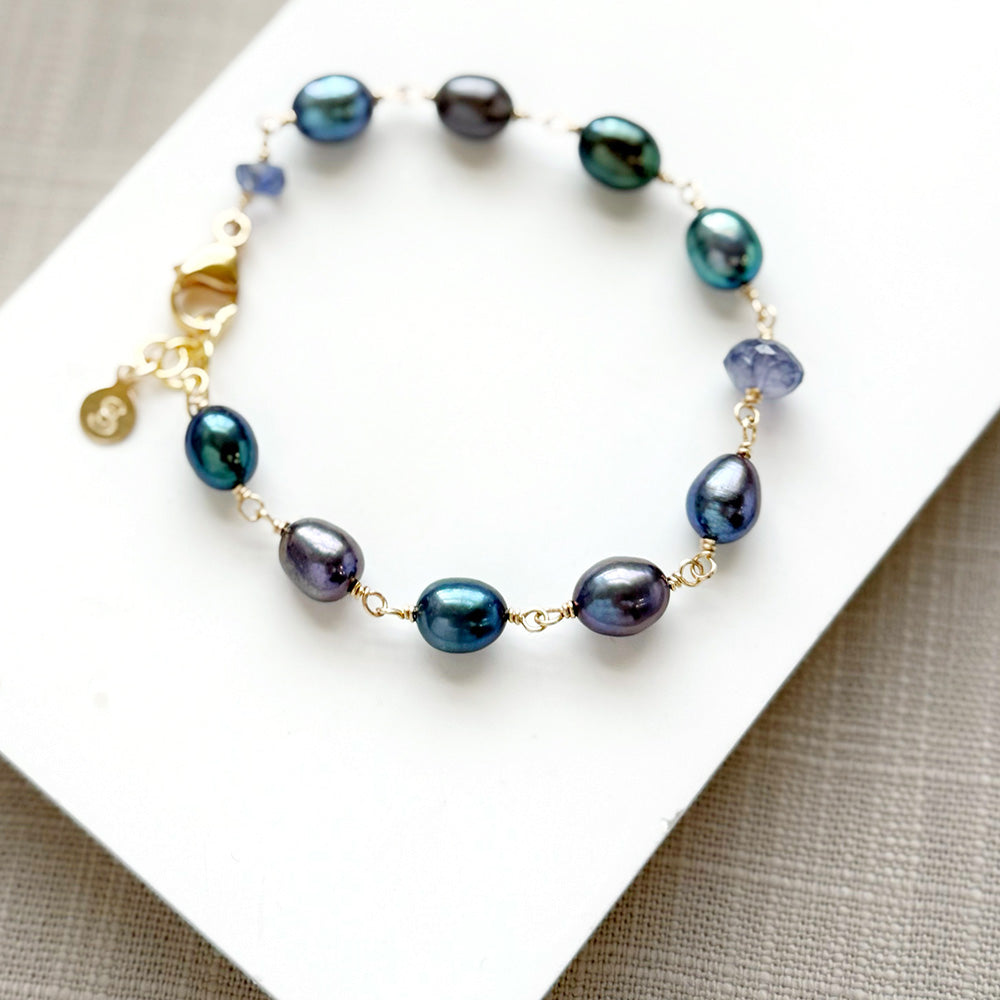 Peacock pearl and iolite bracelet on a white dish