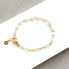 Pearl and chain bracelet on a white plate