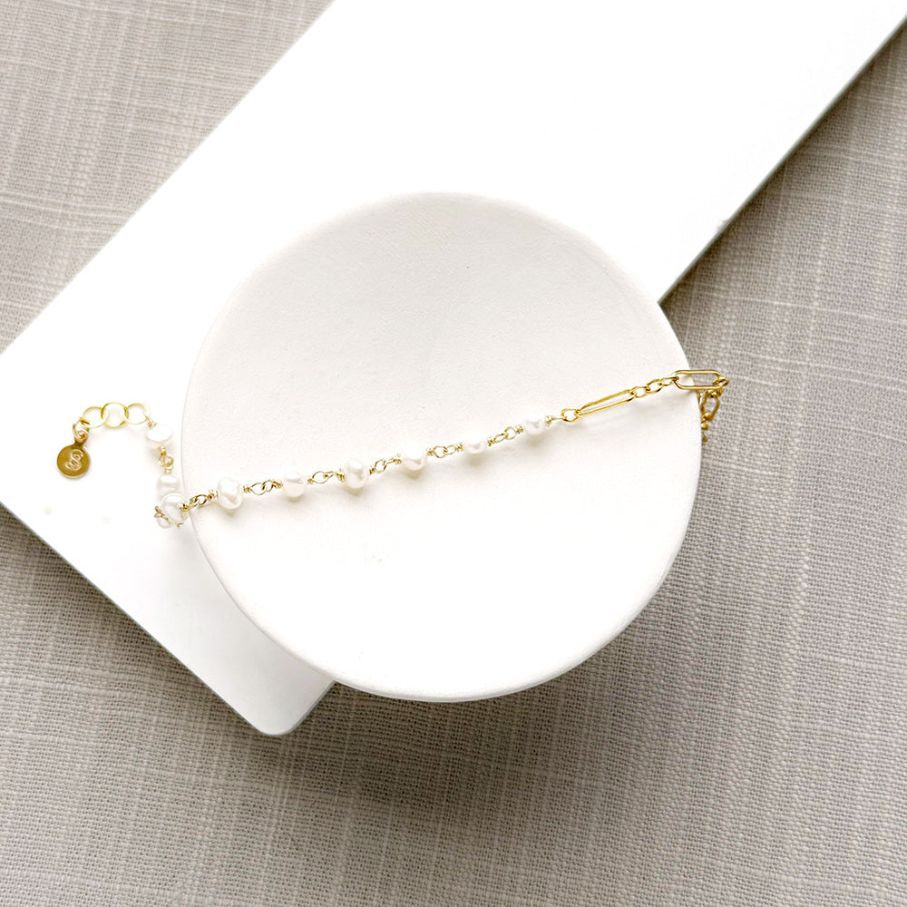 Pearl and chain bracelet in a white dish
