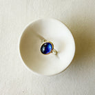 Ring with a purple tanzanite gemstone on a white dish