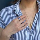 Person wearing a ring with a purple tanzanite gemstone