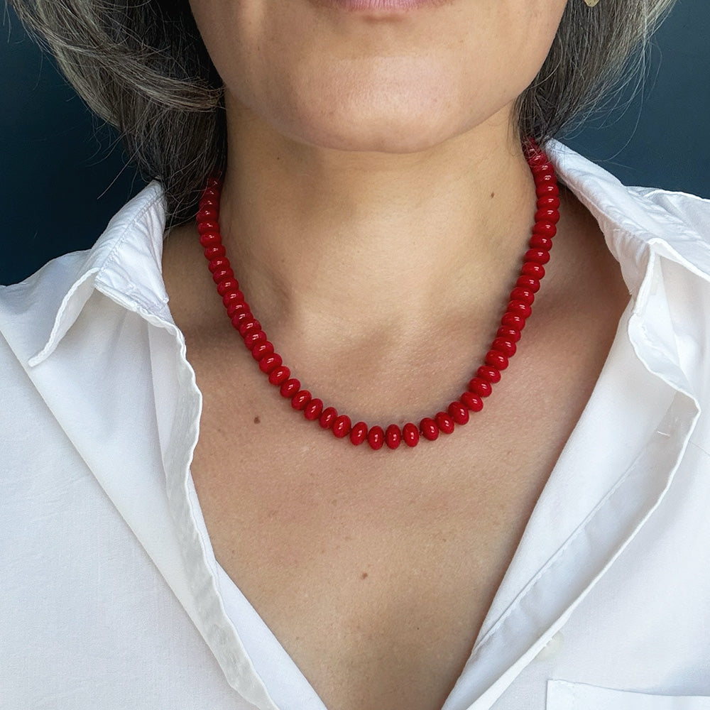 Woman wearing red coral knotted necklace and a white shirt