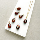 Tiger Eye charm with inset cz stone in a white dish