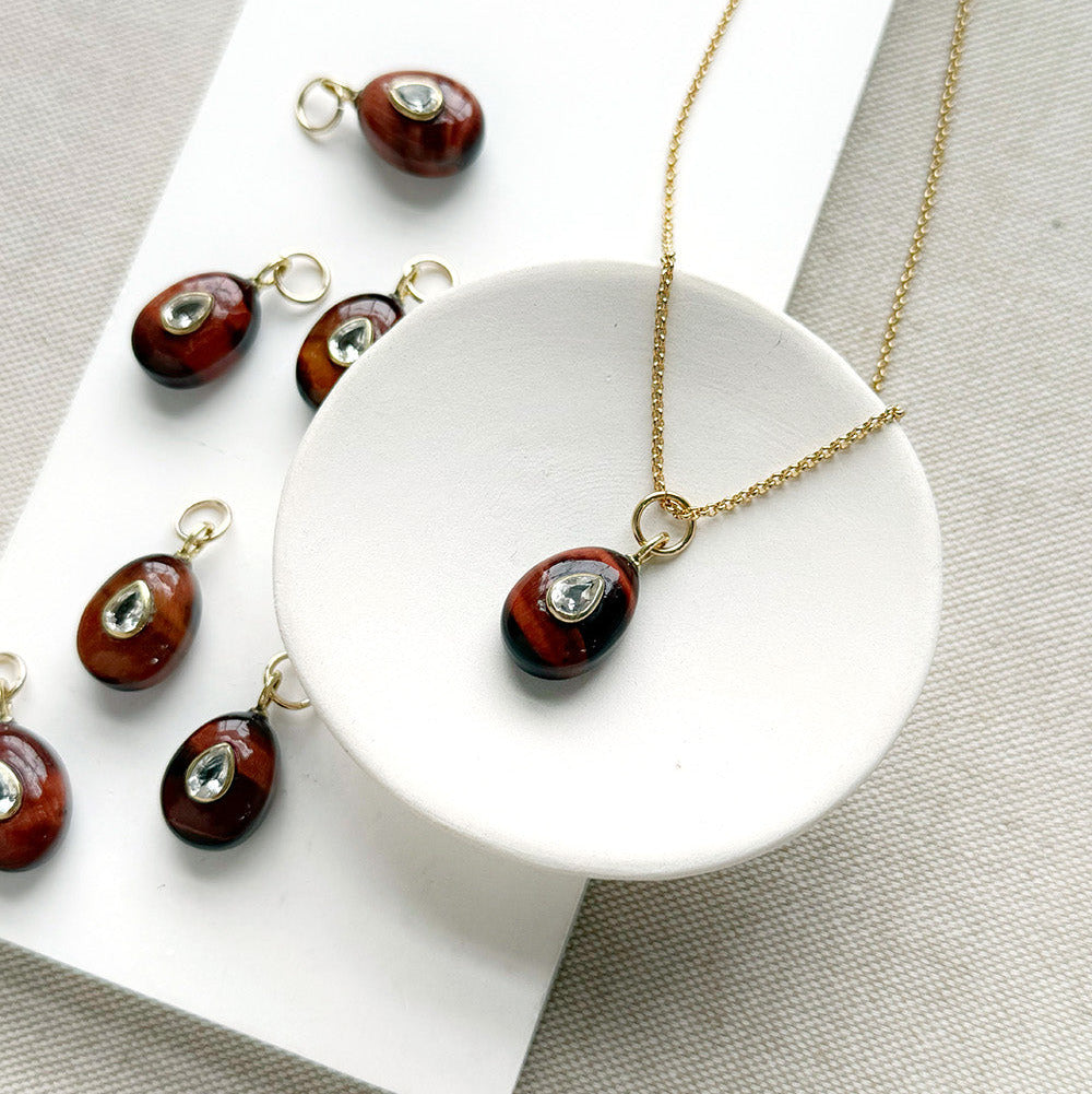 Tiger Eye charm with inset cz stone in a white dish
