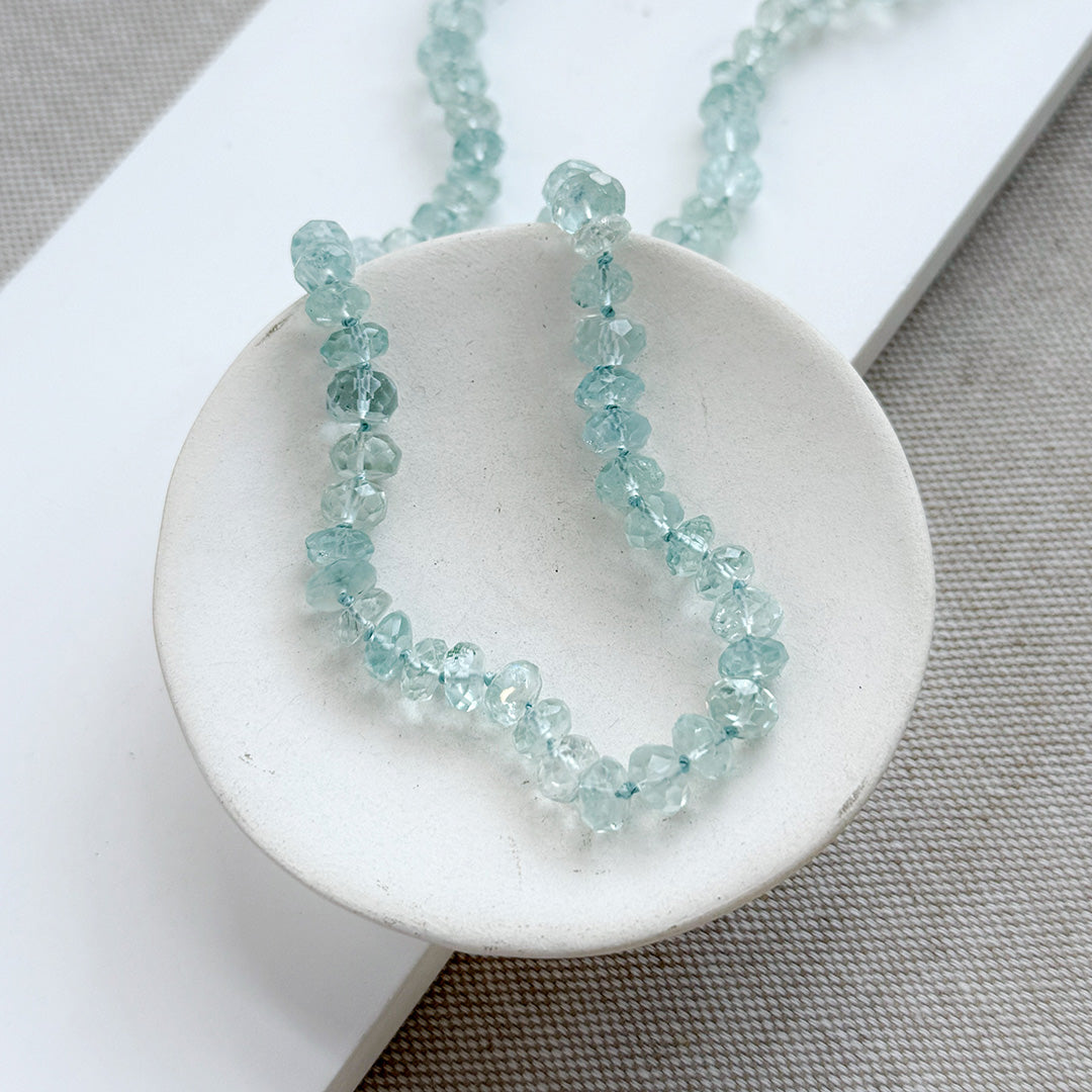 Light blue topaz knotted necklace in a white dish