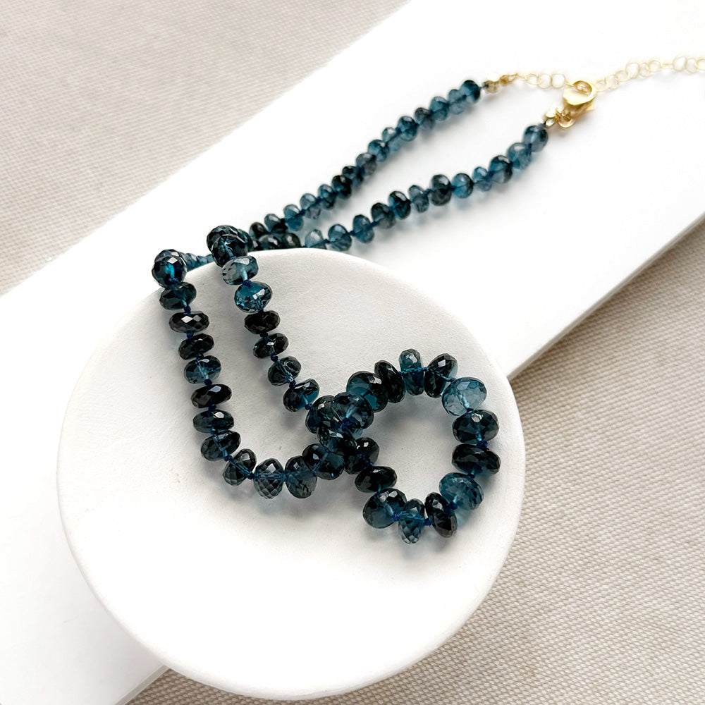 London Blue knotted necklace in a white dish