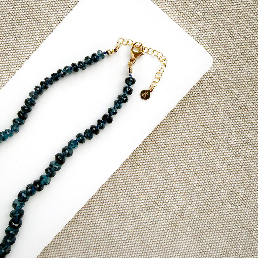 London Blue knotted necklace on a white dish