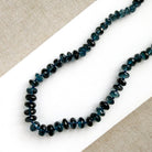 London Blue knotted necklace on a white dish