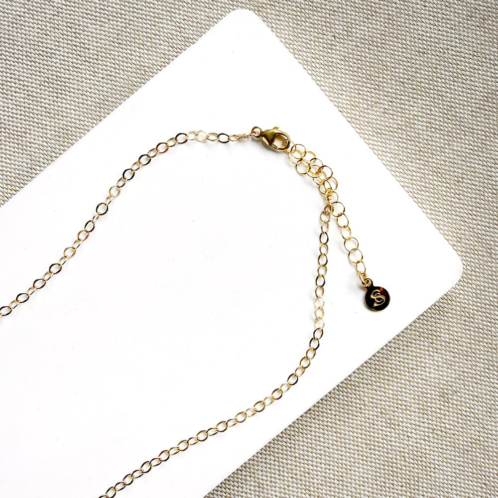 Clasp detail of gold necklace with dangling teardrop-shaped Watermelon Tourmaline gemstones in pink, green, and teal