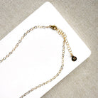 Clasp detail of gold necklace with dangling teardrop-shaped Watermelon Tourmaline gemstones in pink, green, and teal