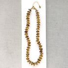 large whiskey quartz knotted necklace on a white plate
