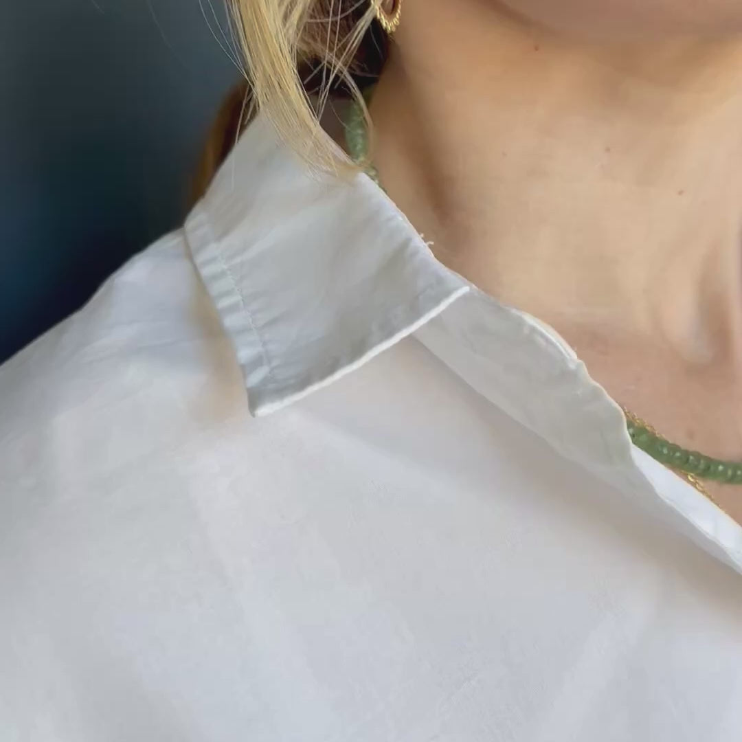 Woman wearing green kanite gemstone necklace with gold pendant