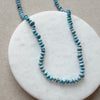 Close up of Golden Hill turquoise knotted necklace on a white round dish.