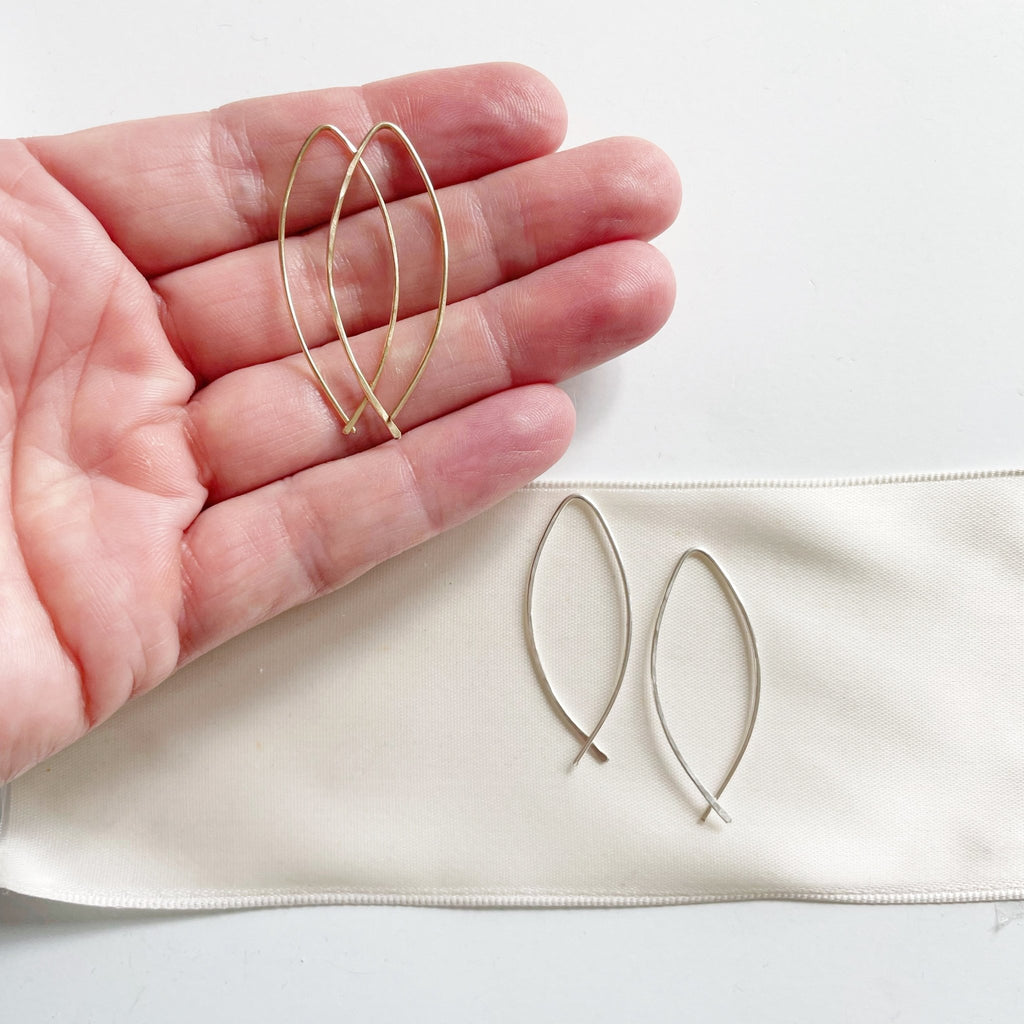 Alice Earrings by Sarah Cornwell Jewelry. Simple lightweight gold and silver threader earrings on white background with hand.