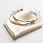 2 gold and silver textured bangle bracelets with the words "always with you" stamped on the inside. Always with You Bangle by Sarah Cornwell Jewelry