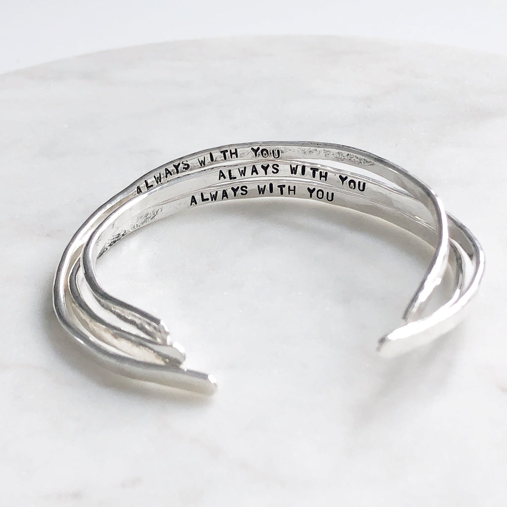 3 silver textured bangle bracelets with the words "always with you" stamped on the inside. Always with You Bangle by Sarah Cornwell Jewelry