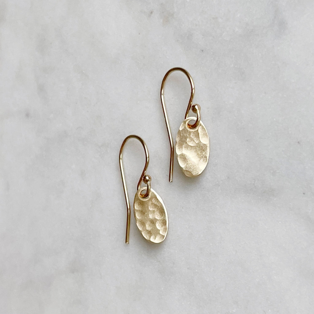 Gold Brooklyn Earrings by Sarah Cornwell Jewelry. Dainty textured gold oval earrings with a .5 in drop on a white background.