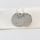 Silver Buffay Earrings by Sarah Cornwell Jewelry. Lightweight, shimmery, textured 1 inch silver disc earrings on a white background.