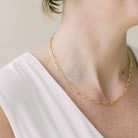 Woman's neck wearing white shirt with chunky large link paperclip chain layering necklace. Charleston Necklace by Sarah Cornwell Jewelry