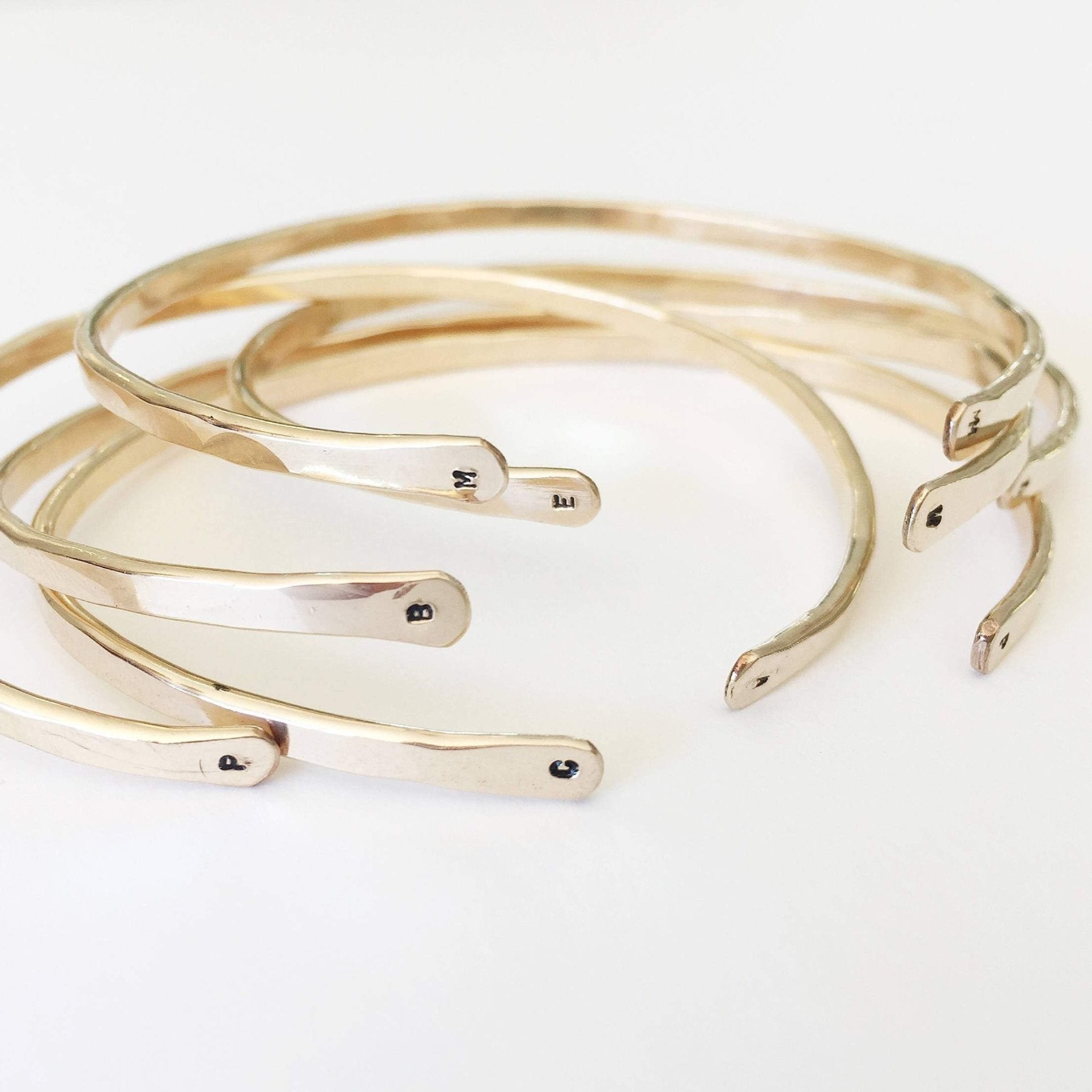 5 gold textured bangle bracelets with initials stamped on both ends. Charlie Bangle  by Sarah Cornwell Jewelry
