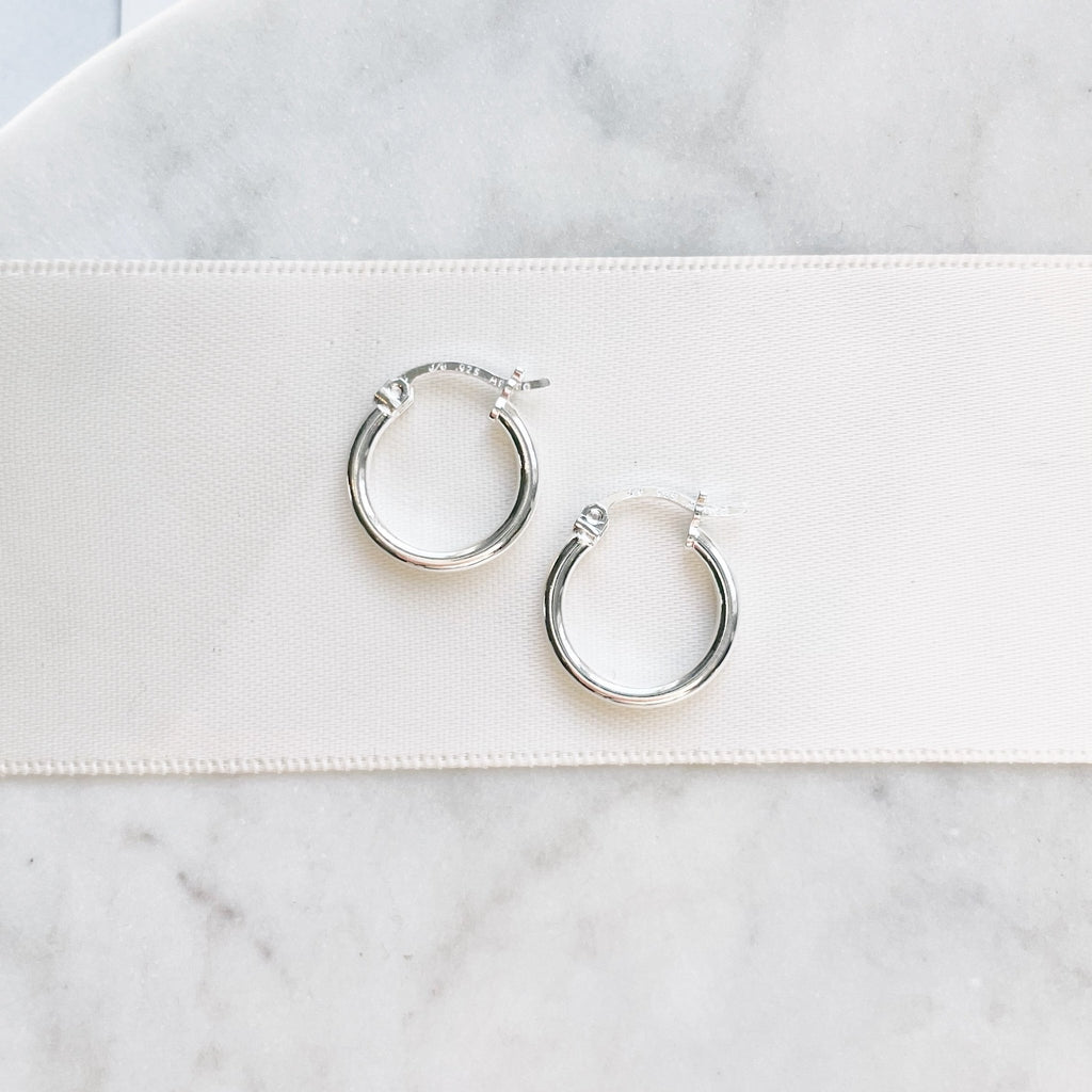 Silver Demi Hoop Earrings by Sarah Cornwell Jewelry. Small, simple, everyday silver hoop earrings on a white background.