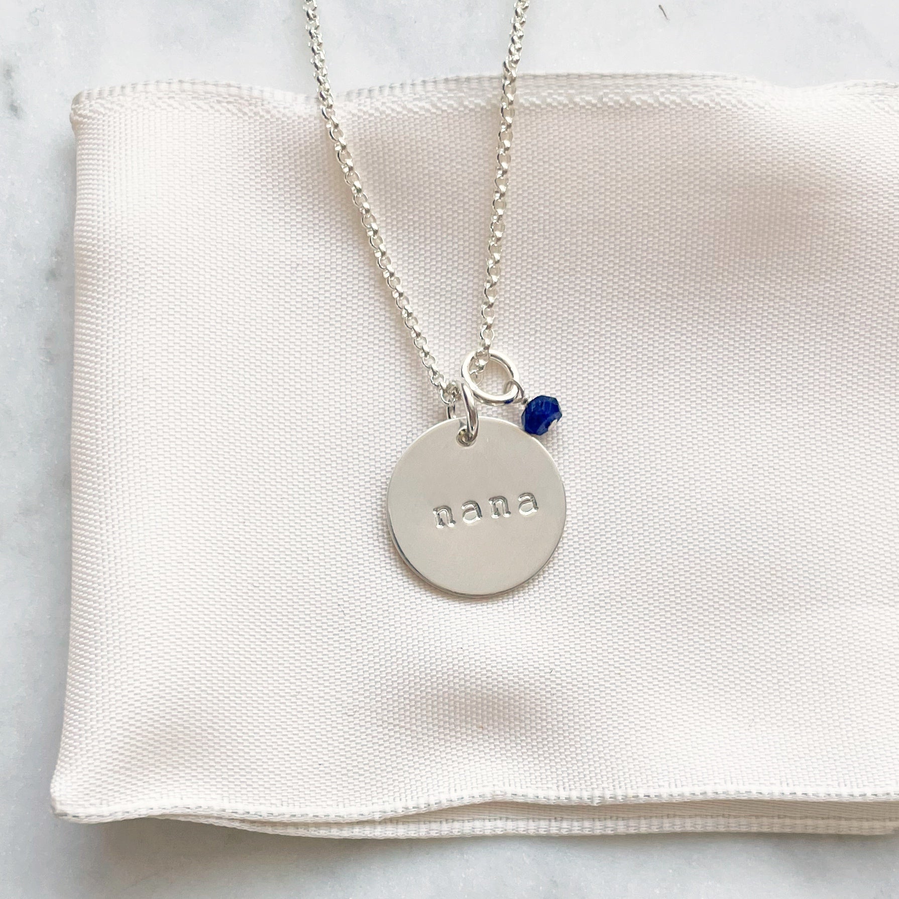 Silver nana disc and wire wrapped gemstone necklace with a blue gemstone. Gigi Necklace by Sarah Cornwell Jewelry