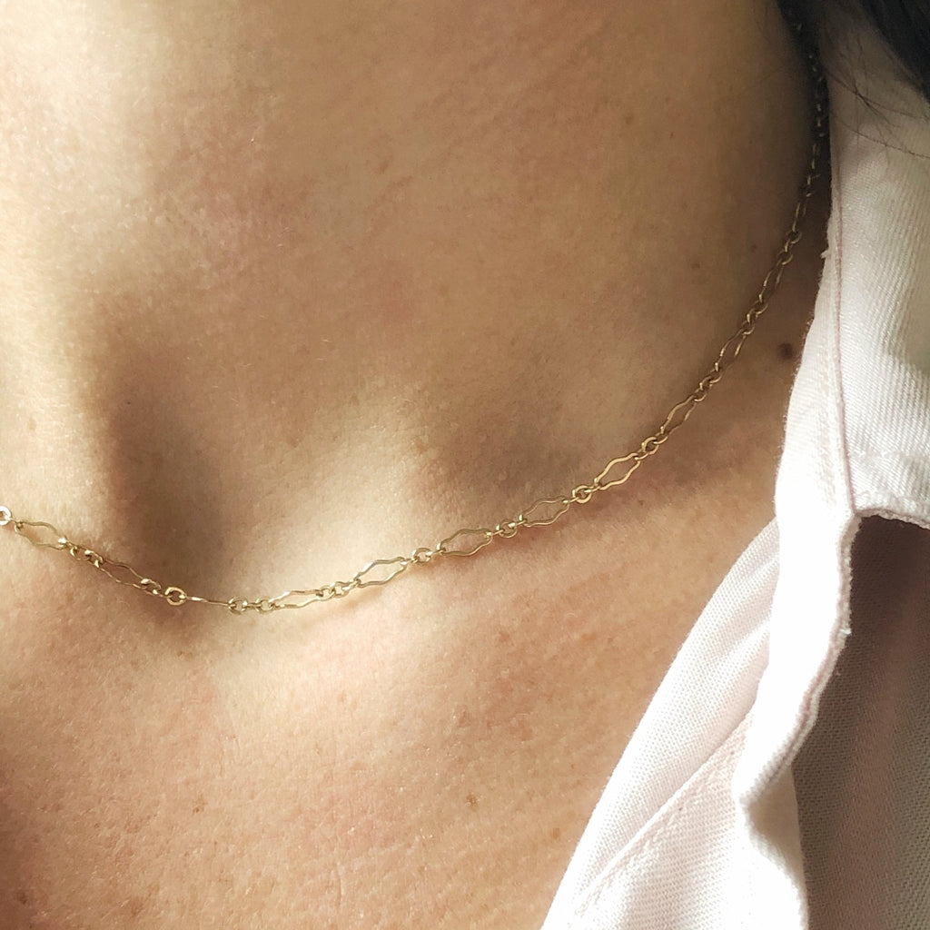 Woman's neckline with white button down shirt and unique shaped links gold layering chain. Halo Chain by Sarah Cornwell Jewelry
