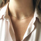 Woman's neckline with white button down shirt and unique shaped links gold layering chain. Halo Chain by Sarah Cornwell Jewelry