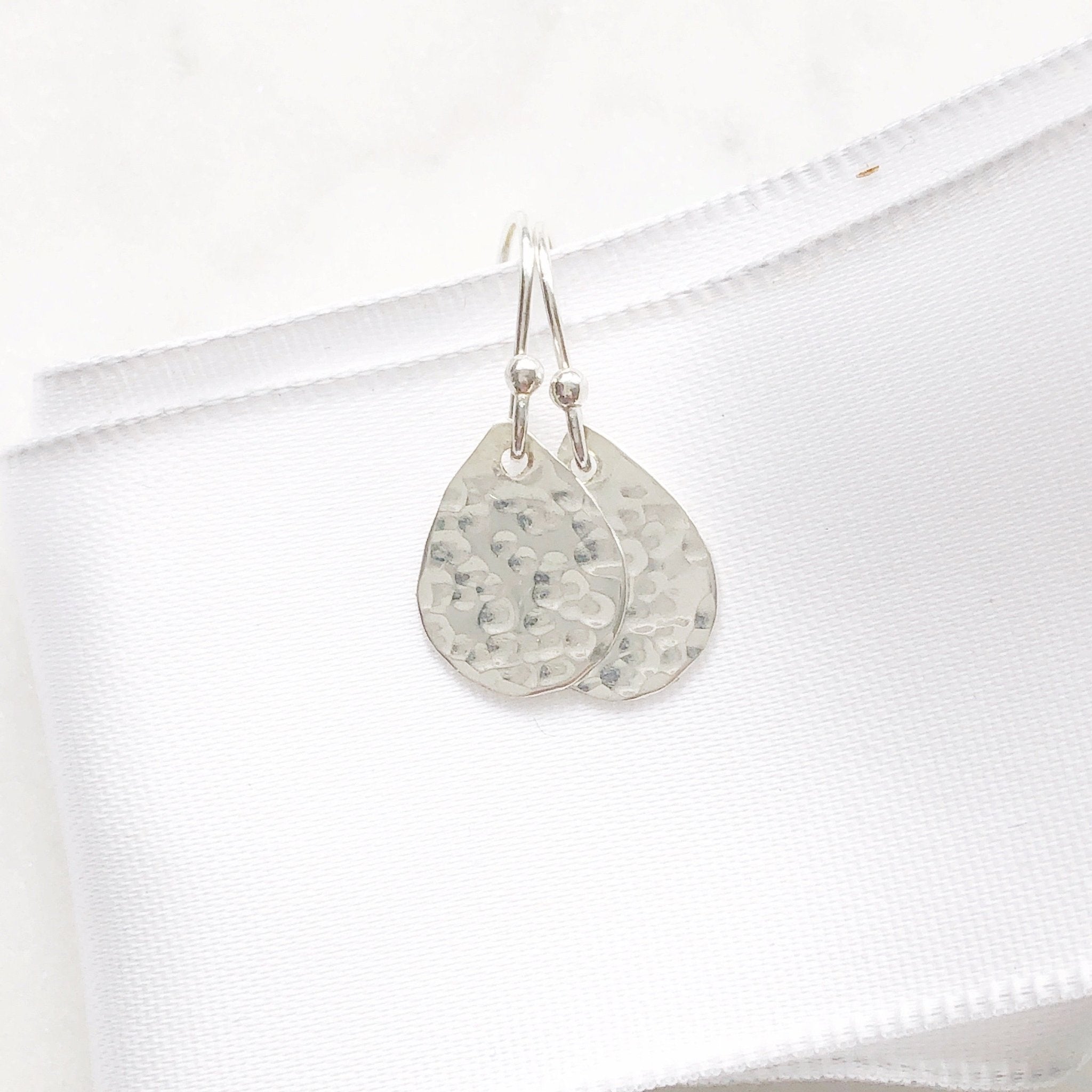 Silver Harvest Moon Earrings by Sarah Cornwell Jewelry. Dainty, textured silver teardrop earrings on a white background.