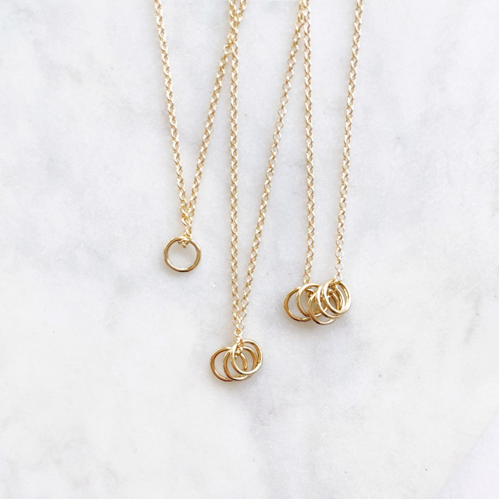 3 gold necklaces with 1, 3 and 5 tiny gold rings. Honor Necklace by Sarah Cornwell Jewelry