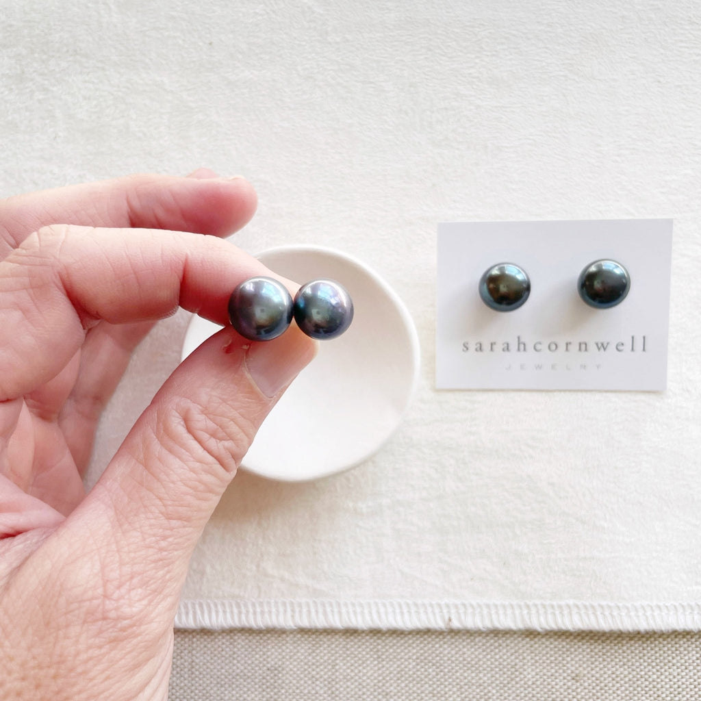 2 pairs of deep blue 11 mm freshwater pearl stud earrings in a silver setting. Hudson Pearl Studs by Sarah Cornwell Jewelry