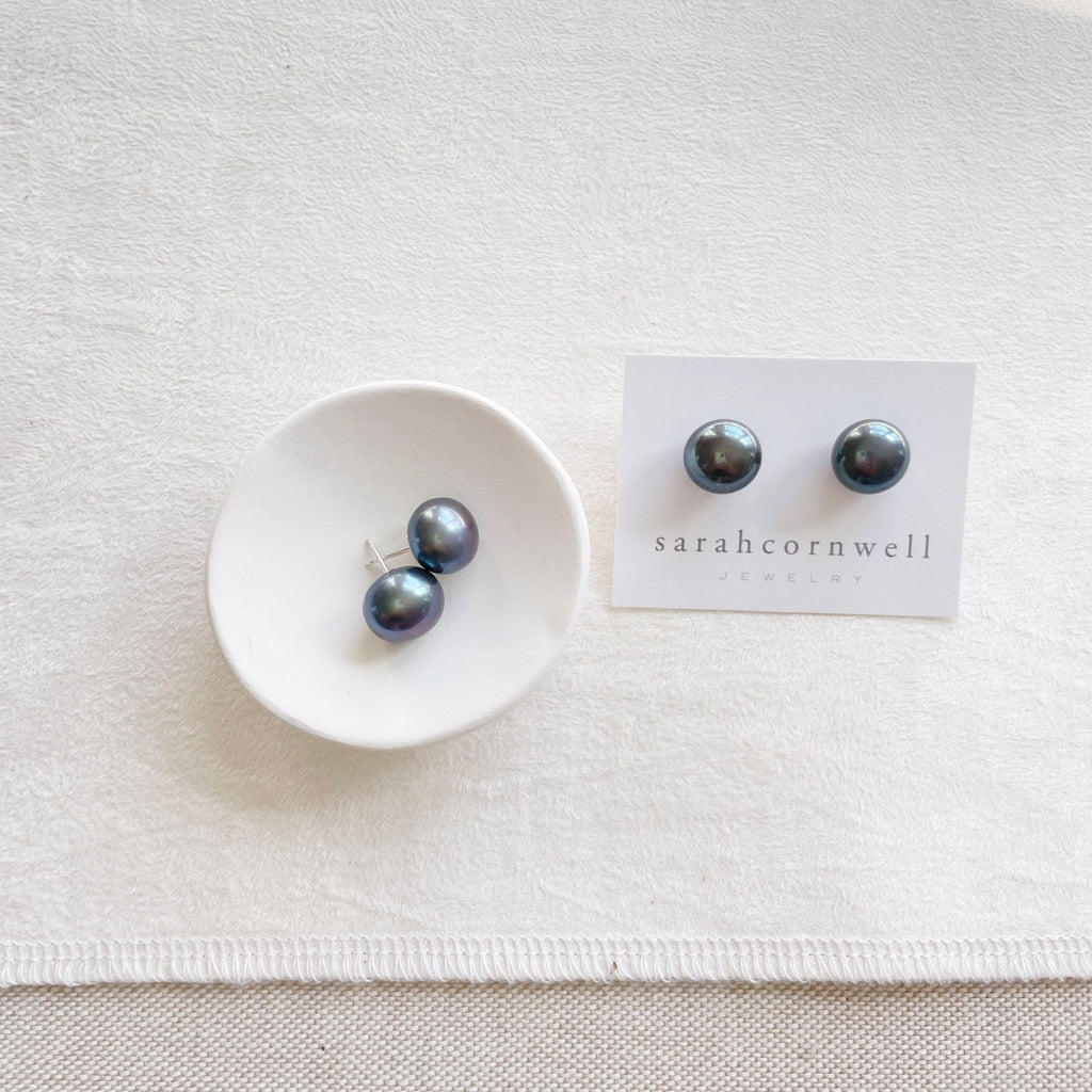 2 pairs of deep blue 11 mm freshwater pearl stud earrings in a silver setting. Hudson Pearl Studs by Sarah Cornwell Jewelry