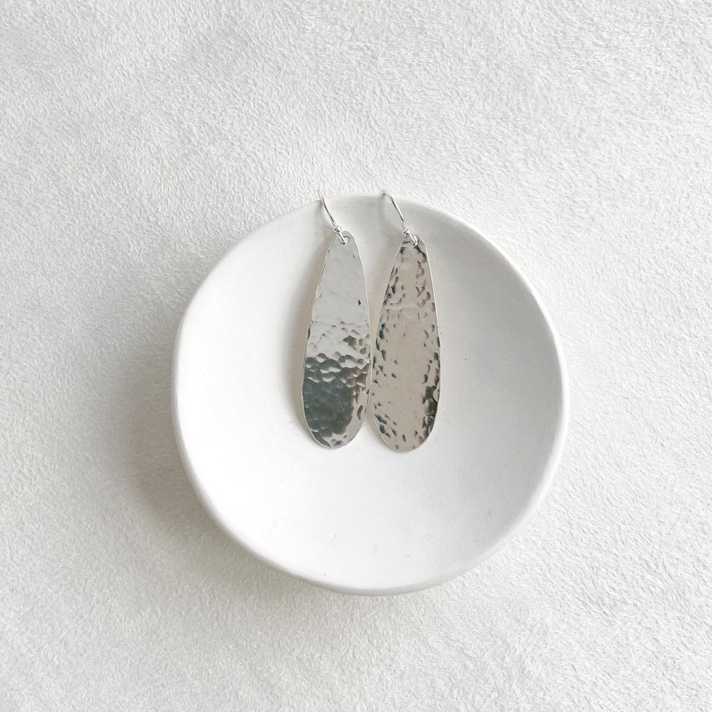 Silver textured long teardrop disc earrings with a 1.5 inch drop. Luna Earrings by Sarah Cornwell Jewelry