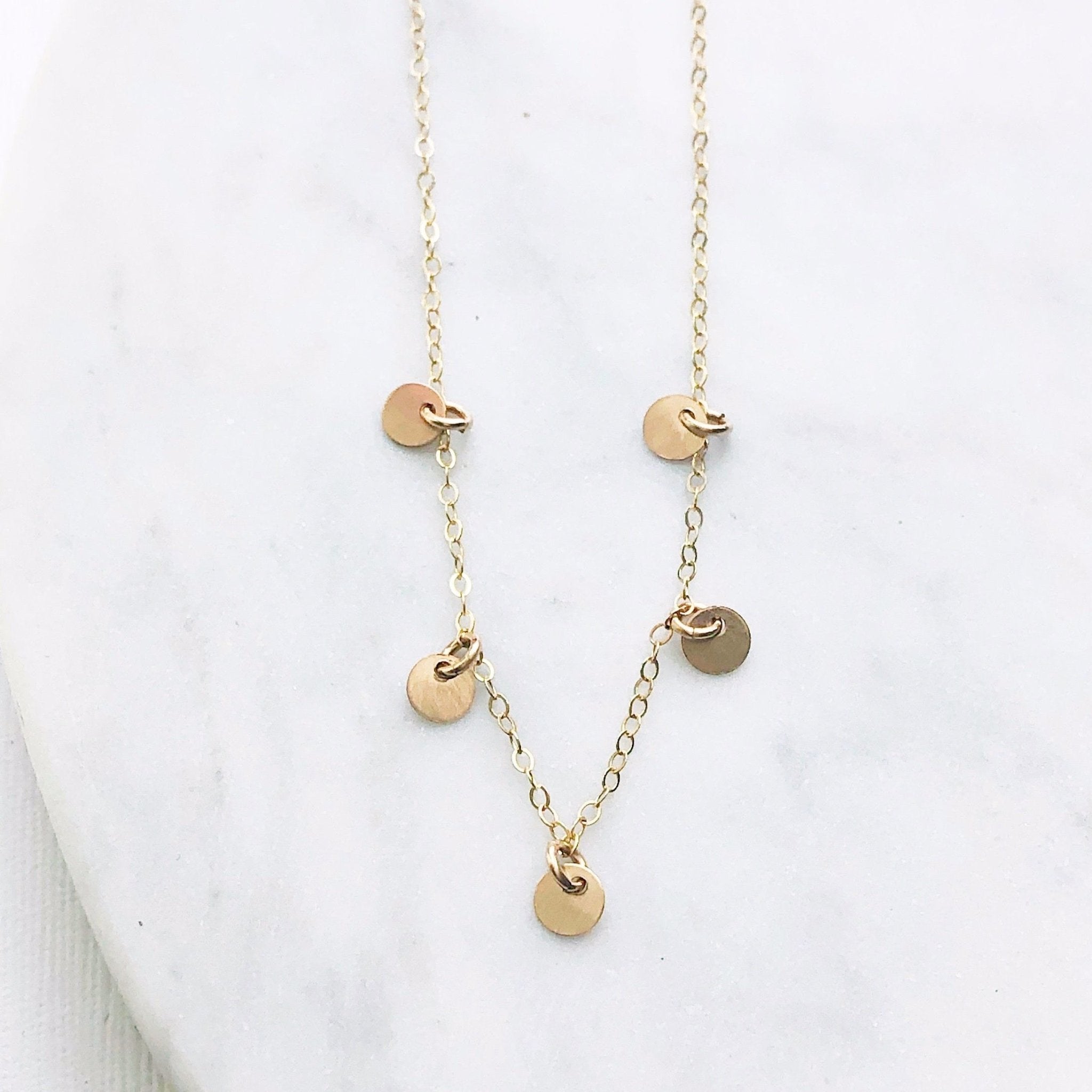 Gold necklace with 5 tiny gold discs. Mae Necklace by Sarah Cornwell Jewelry