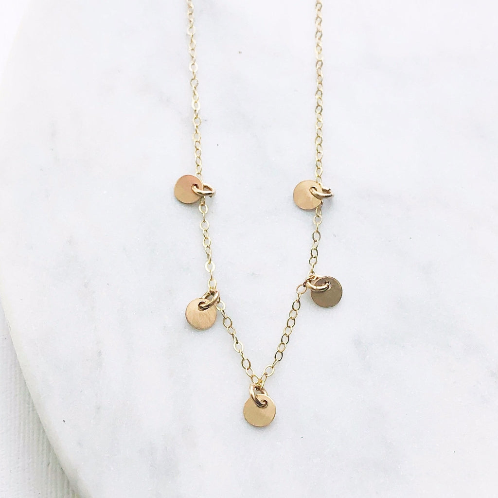 Gold necklace with 5 tiny gold discs. Mae Necklace by Sarah Cornwell Jewelry